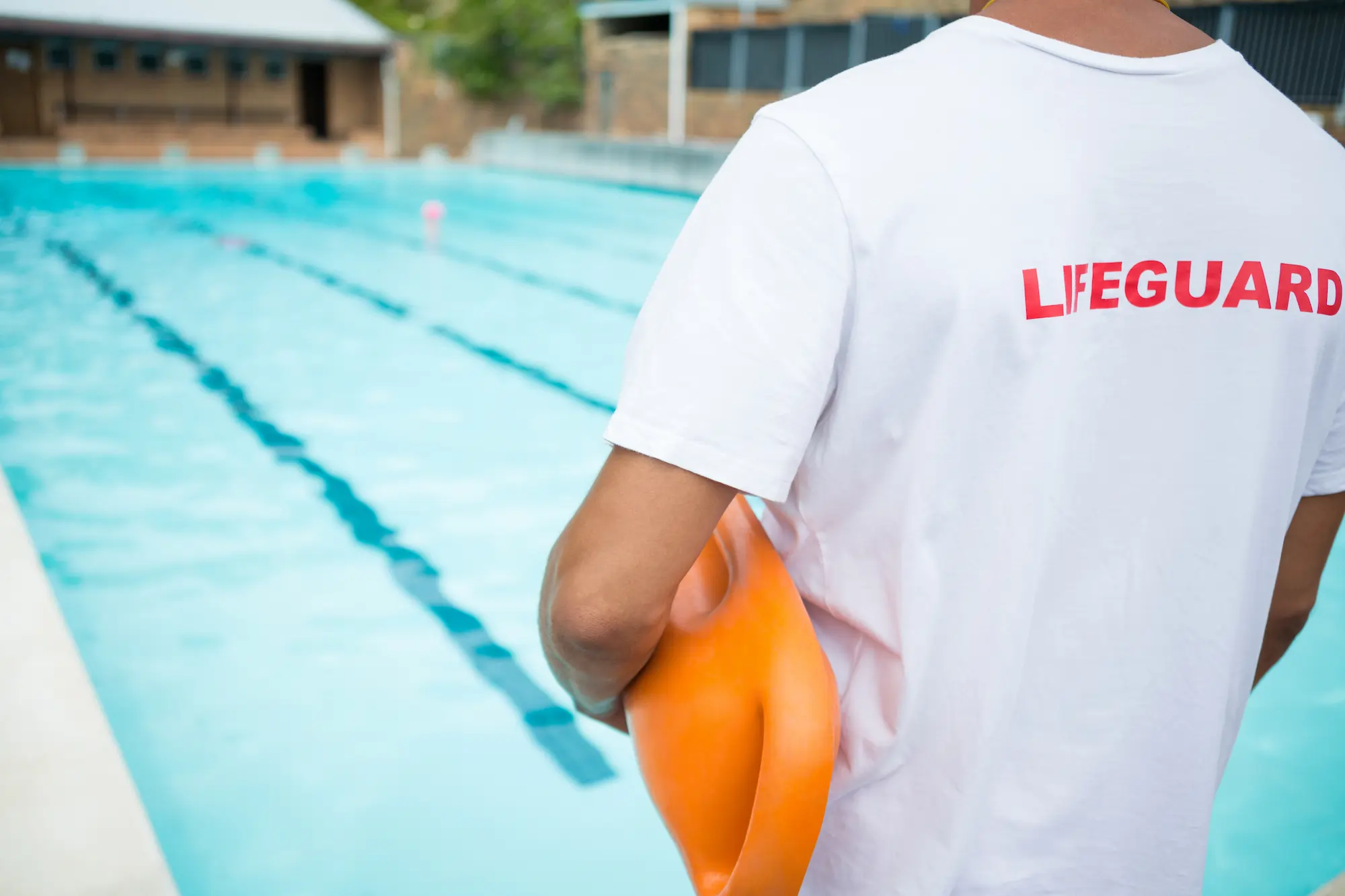 lifeguard-standing-with-rescue-buoy-near-poolside-2025-04-03-16-07-10-utc